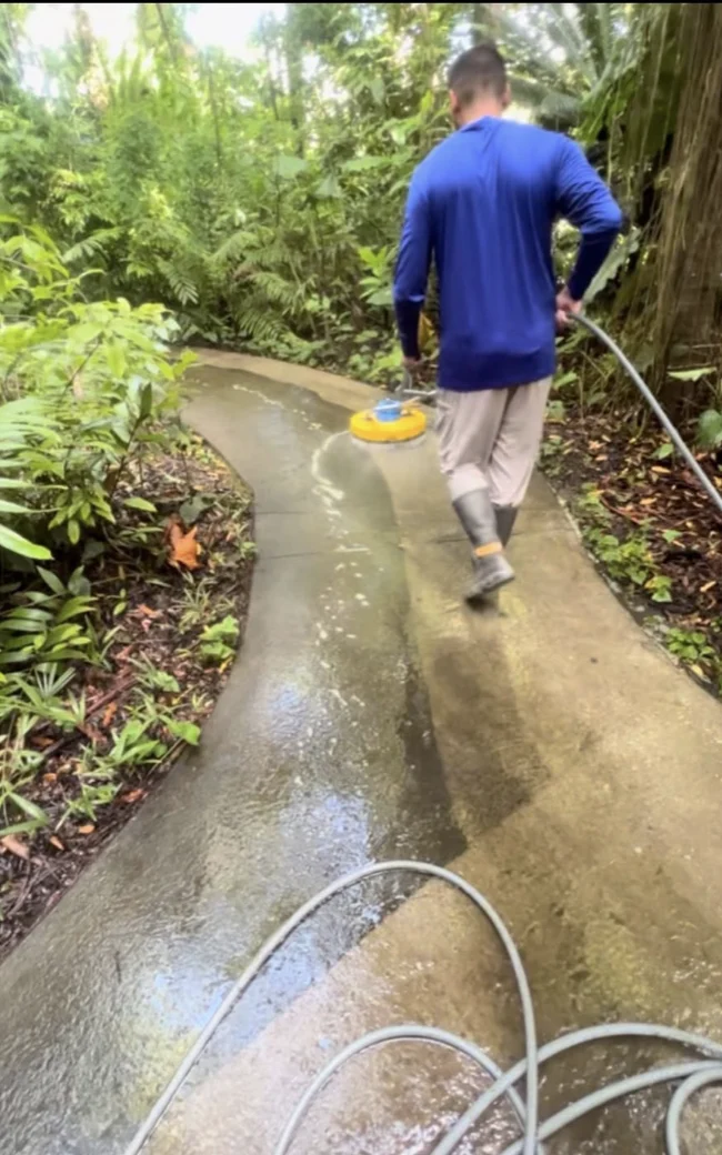 Pressure Kleen technician using a surface cleaner on the rainforest trail at Fairchild Gardens