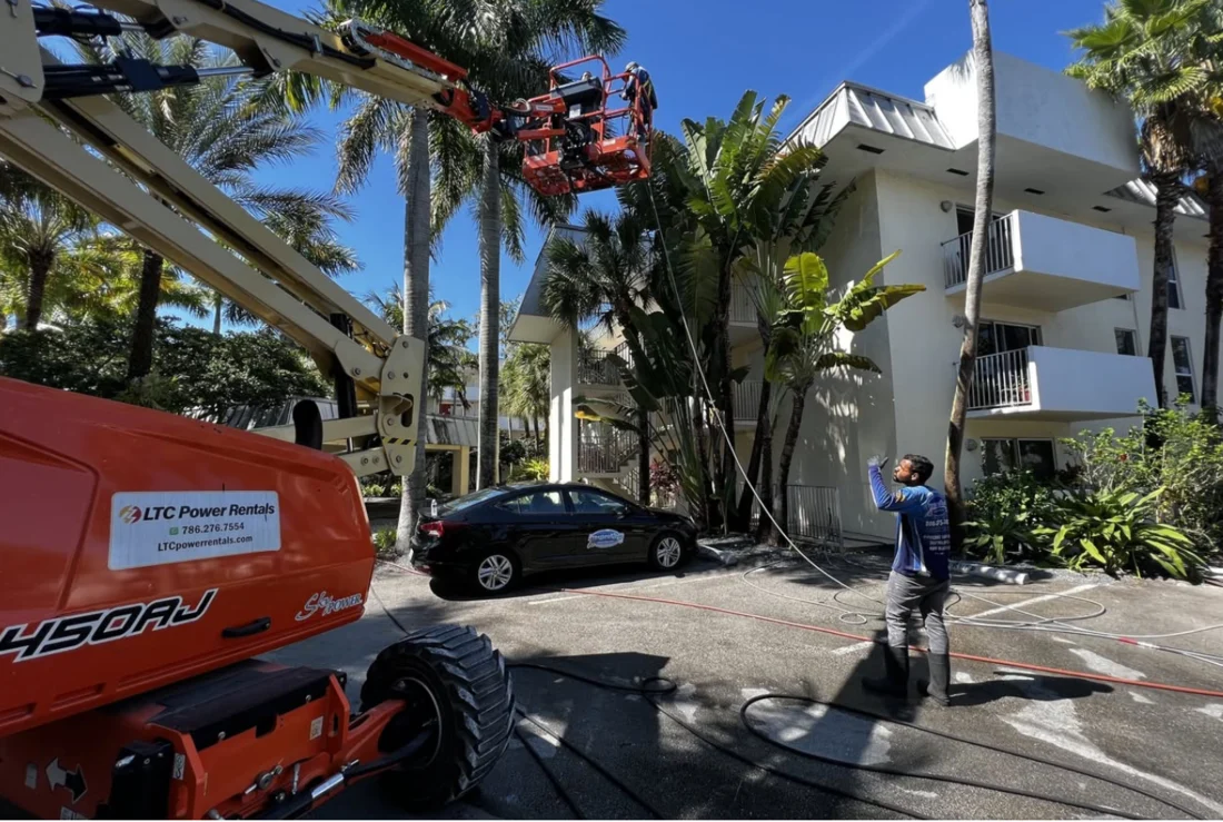 Lift equipment beside a multi-story exterior during the Pinecrest-area building wash